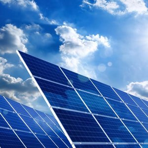 Bewölkter Himmel mit Sonne und einer Solaranlage