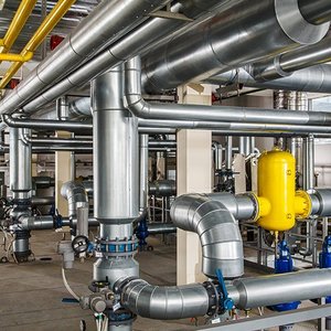Ein Raum mit einer Edelstahl Rohranlage, Pumpen und Kompressoren.